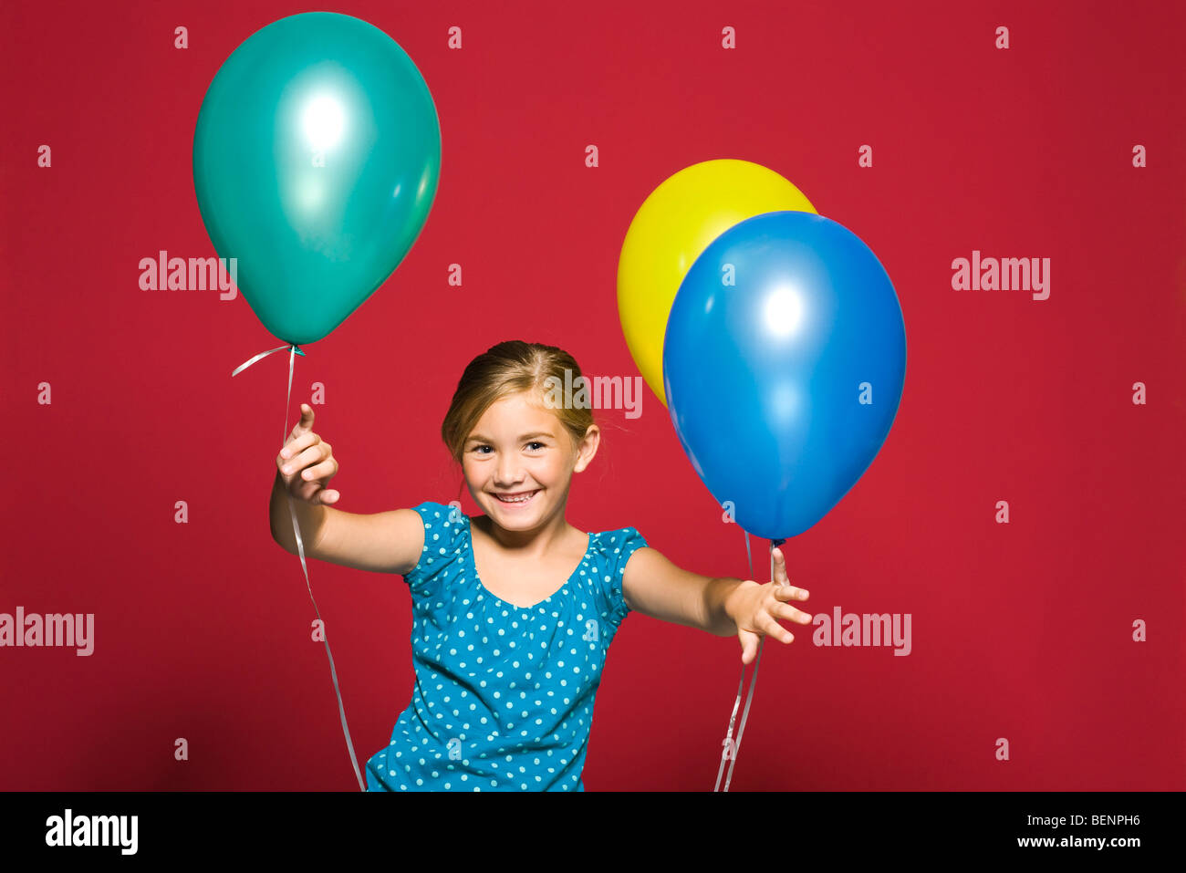 Ragazza in piedi con palloncini, sorridente, ritratto Foto Stock