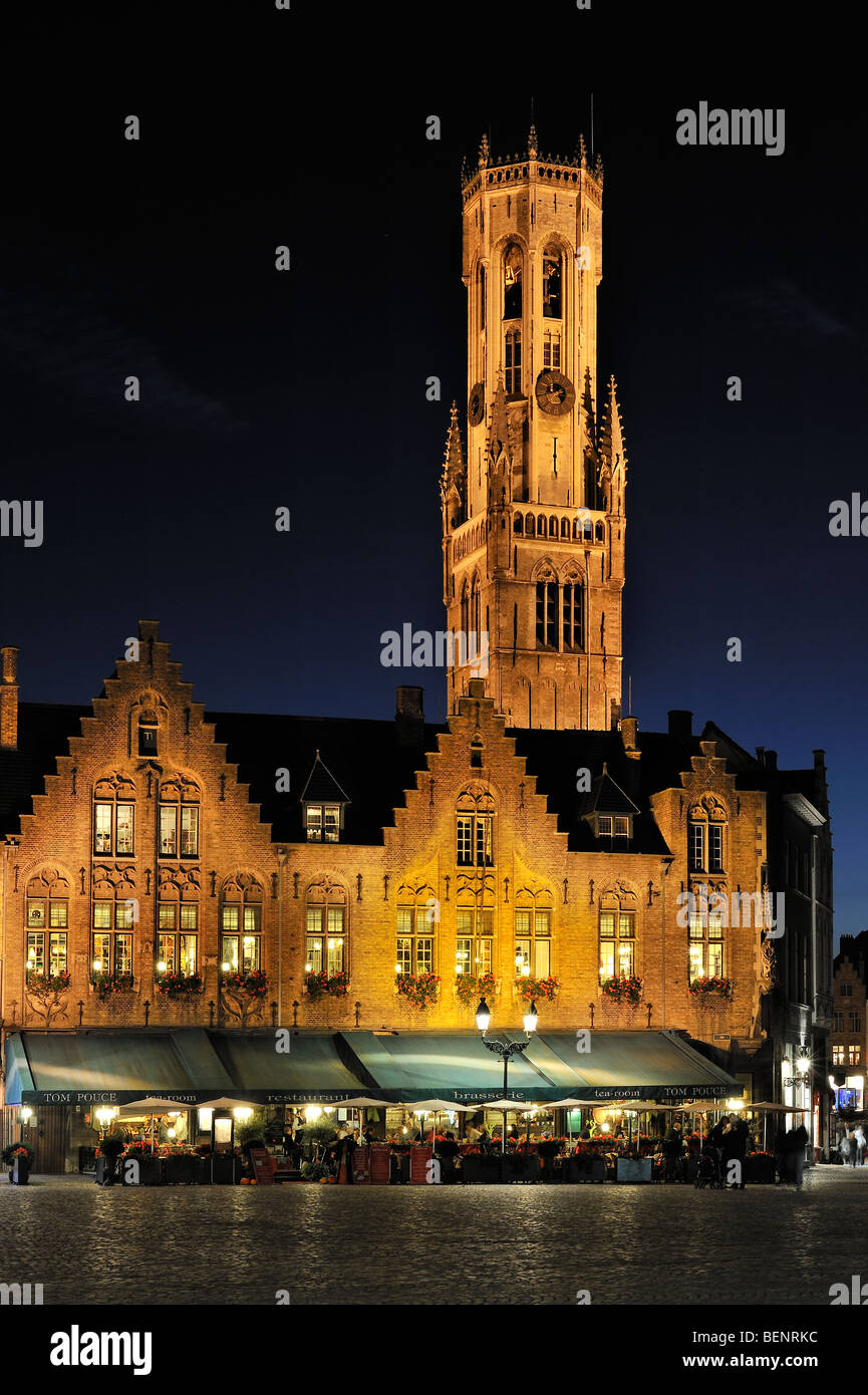 La piazza del borgo alla città di Bruges / Brugge con ristorante e il campanile di notte, Fiandre Occidentali, Belgio Foto Stock