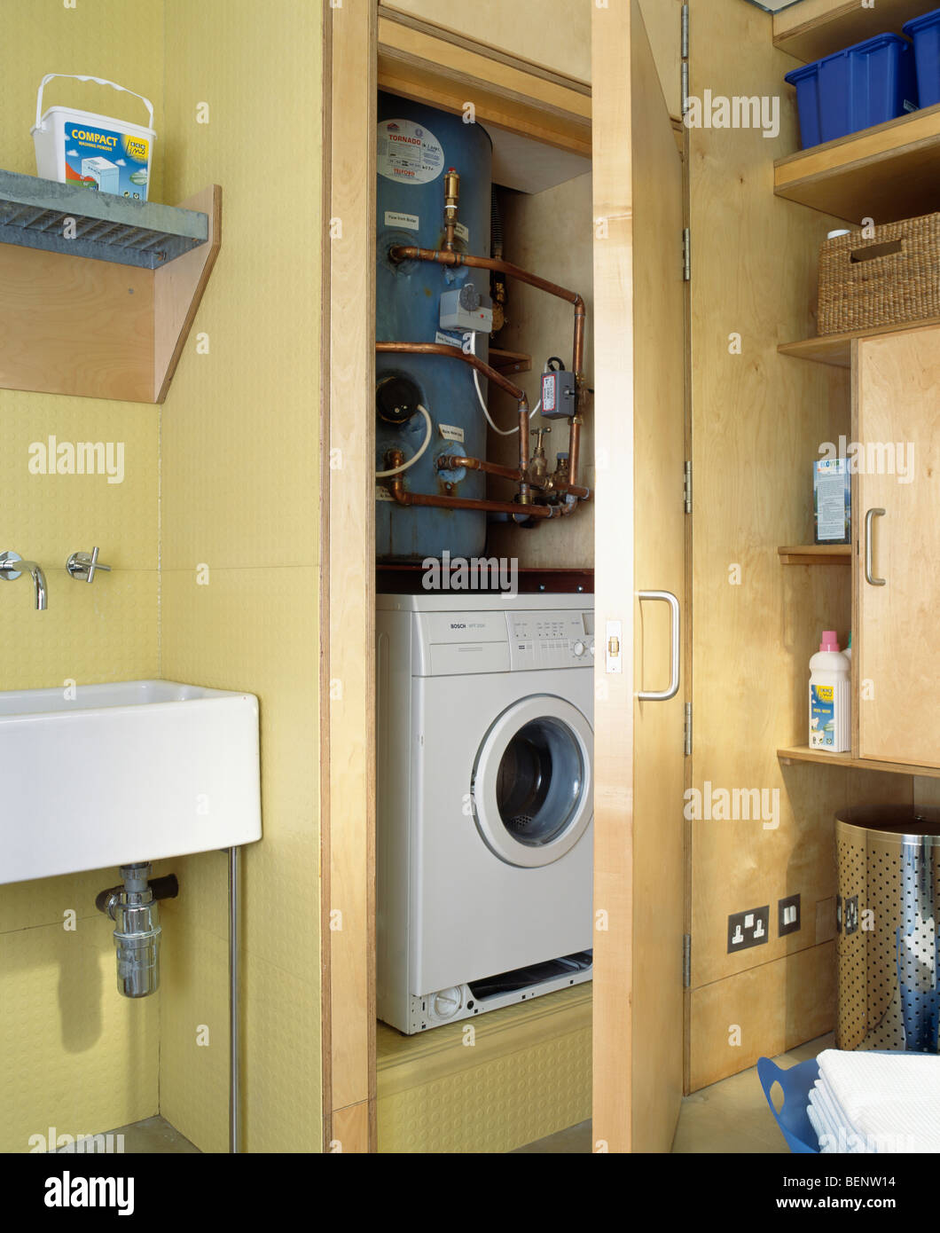 Caldaia sopra lavatrice nascosto dietro la porta in armadio montato nella  camera di utilità Foto stock - Alamy