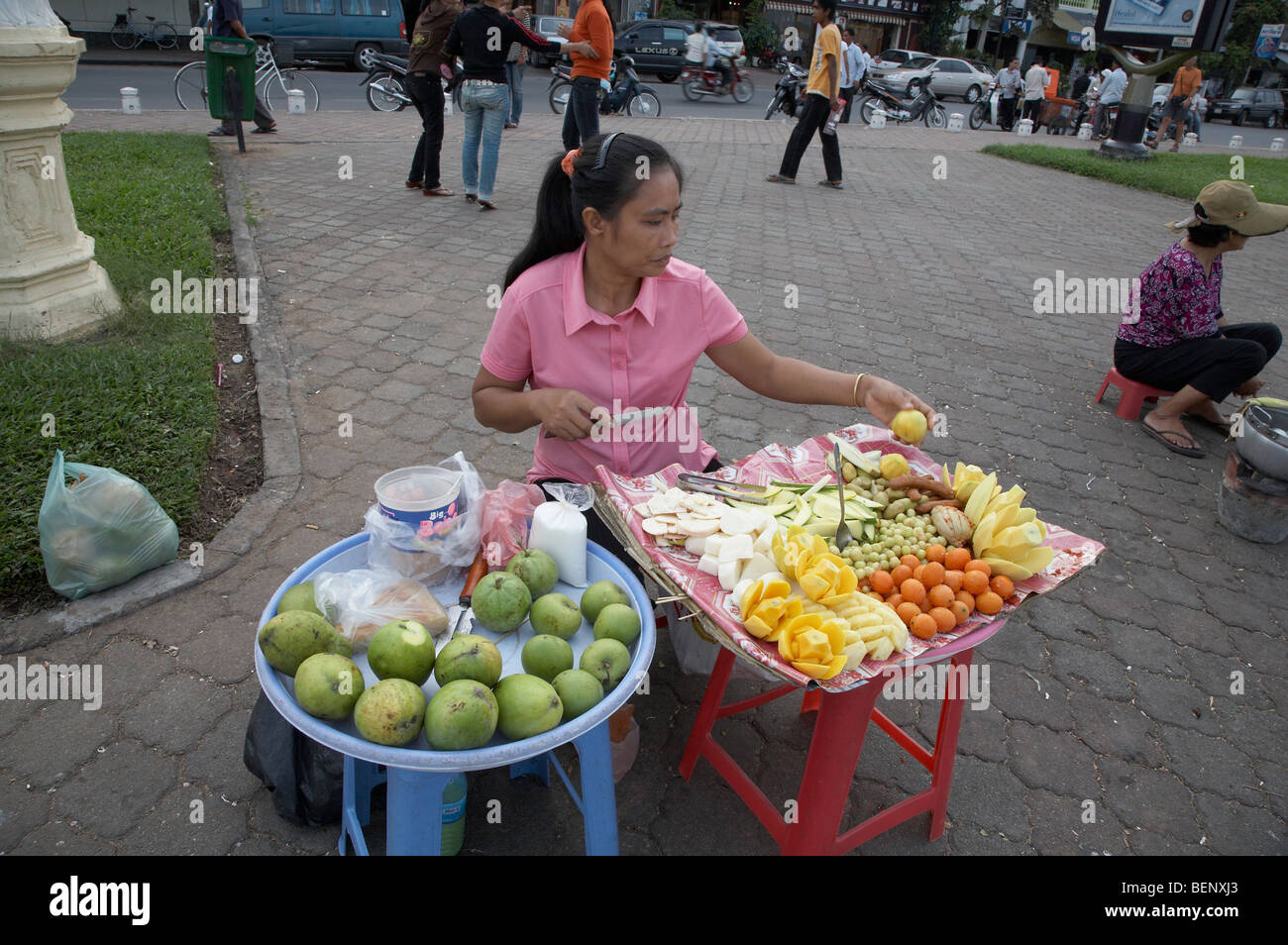 Cambogia folla relax su una Domenica a Phnom Penh. La donna la preparazione e la vendita di frutta. Fotografia di SEAN SPRAGUE 2008 Foto Stock