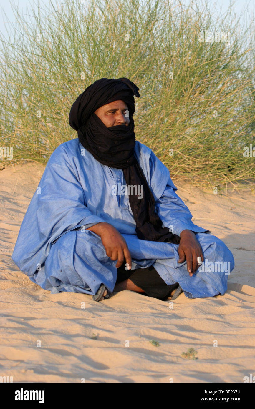 Il Tuareg / Twareg / Touareg seduto e indossando tagelmust / Alasho nel deserto, Timbuktu, Mali, Africa occidentale Foto Stock