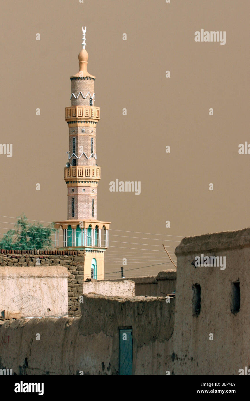 Minareto, alta guglia della moschea e di colore marrone sky causata dalla sabbia del deserto di avvicinamento tempesta di sabbia, Sudan, Nord Africa Foto Stock