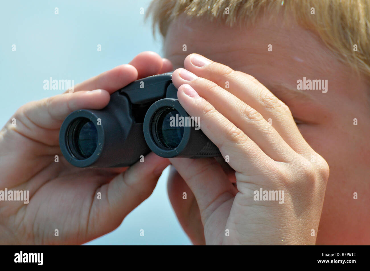 Ragazzo che guarda attraverso il binocolo per vedere le cose lontano Foto  stock - Alamy
