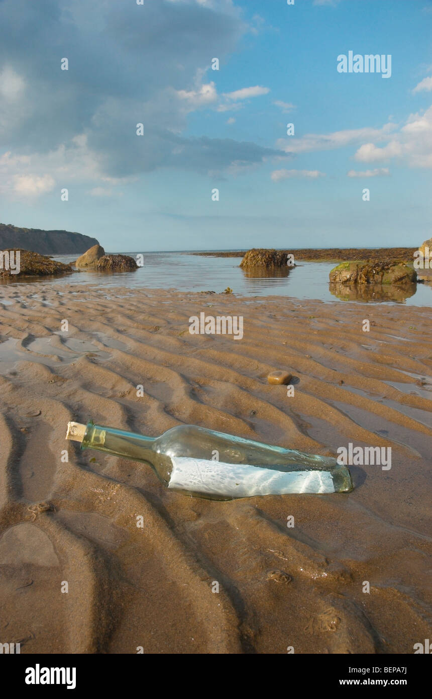 Bottiglia con un messaggio lavato fino a una spiaggia Foto Stock