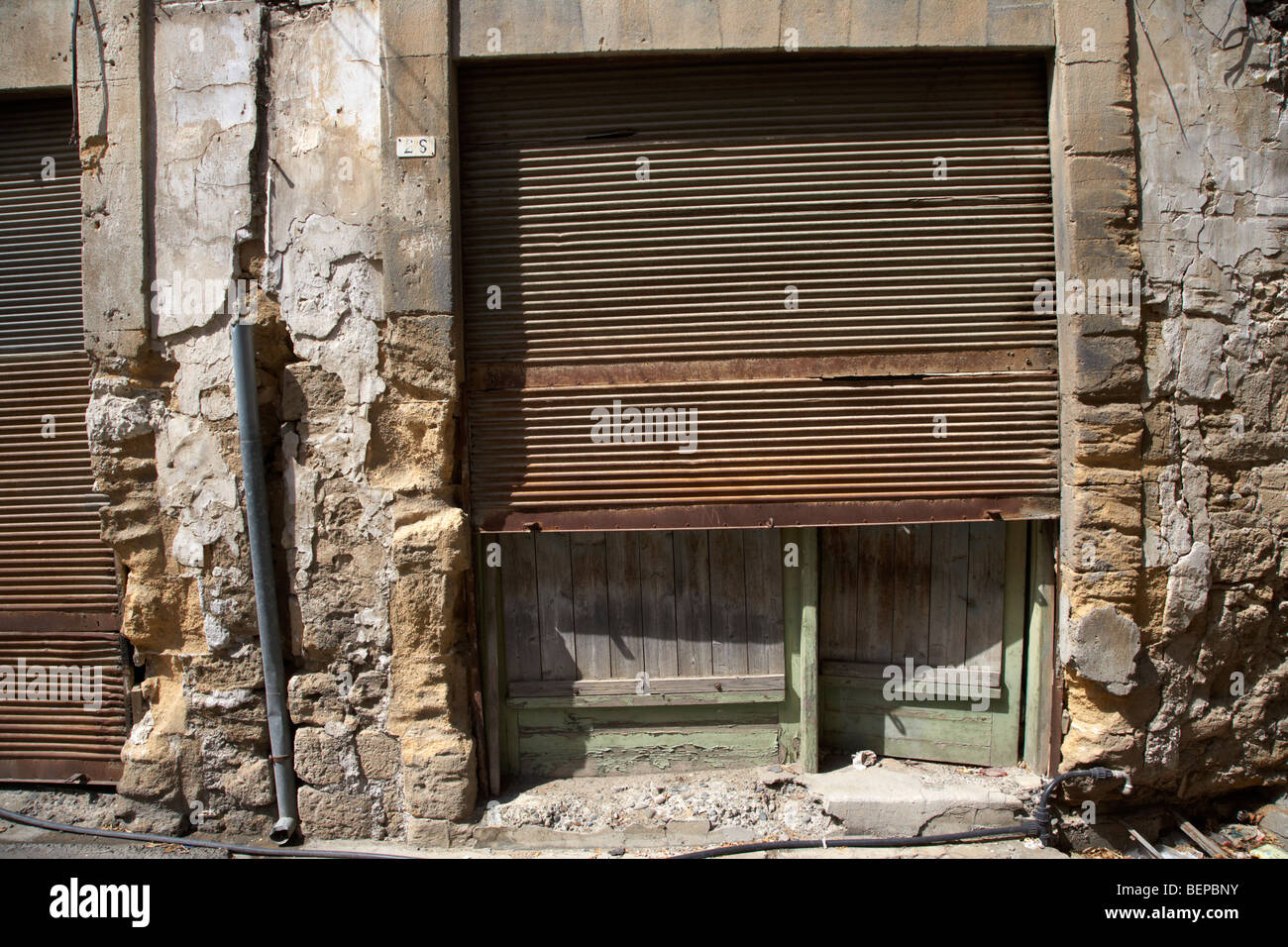 Abbandonato turco-cipriota sinistra shopfront dal 1974 nella ristretta area dell'ONU zona di buffer nel verde della linea che divide Cipro Foto Stock