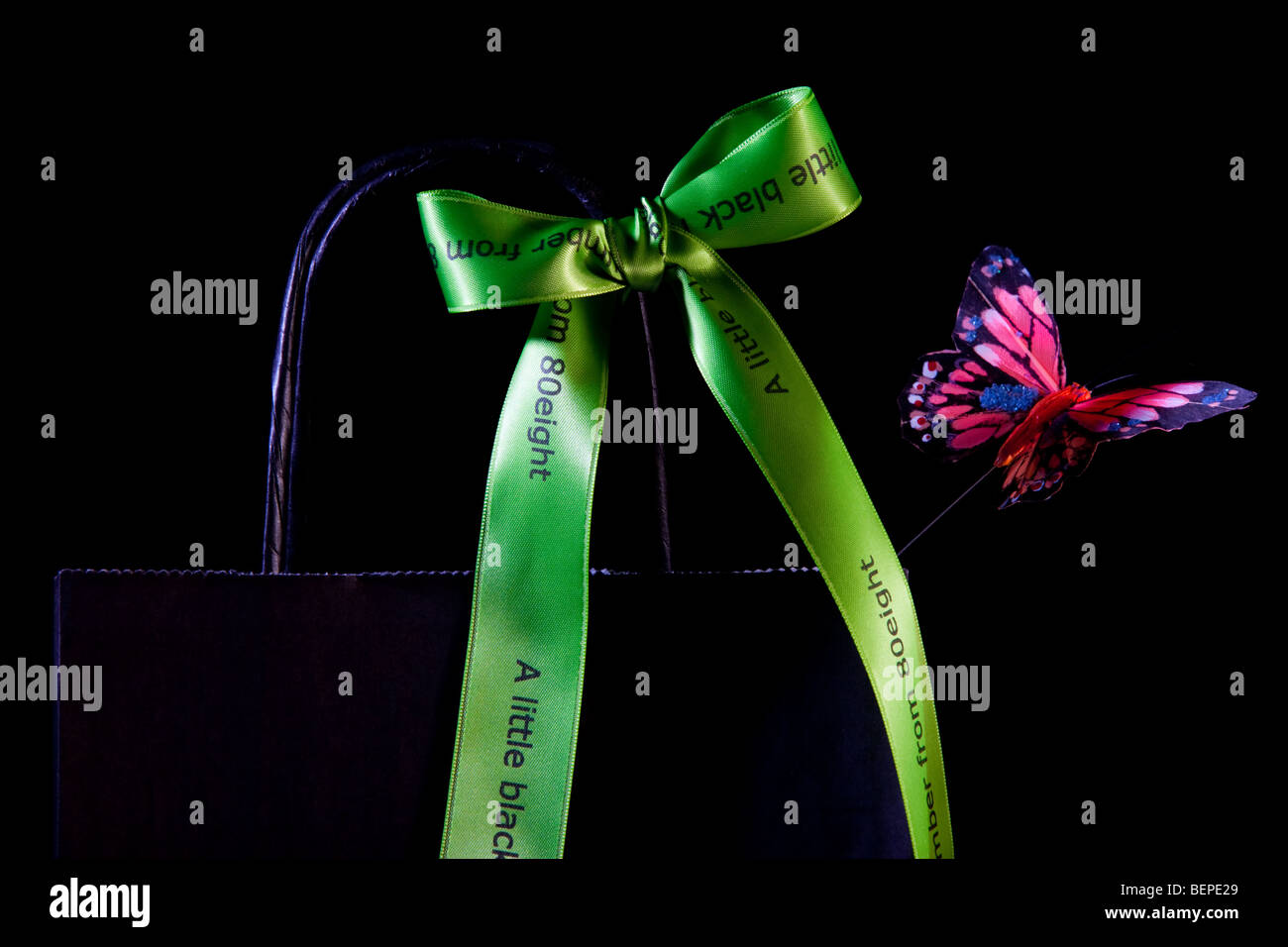 Una carta nera borsa con un nastro verde bow Foto Stock