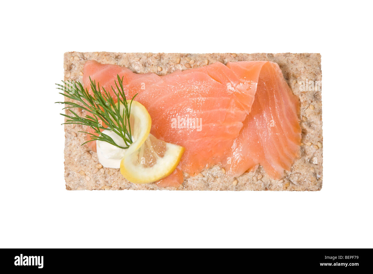 Una fetta di salmone affumicato su pane piatto con ciuffo di aneto e fetta di limone. Foto Stock