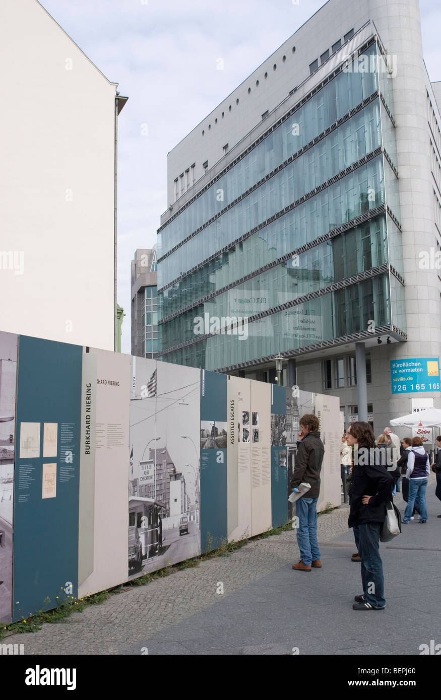 I turisti guarda la documentazione Muro di Berlino al Checkpoint Charlie, il viale Friedrichstraße Berlino - Germania Foto Stock