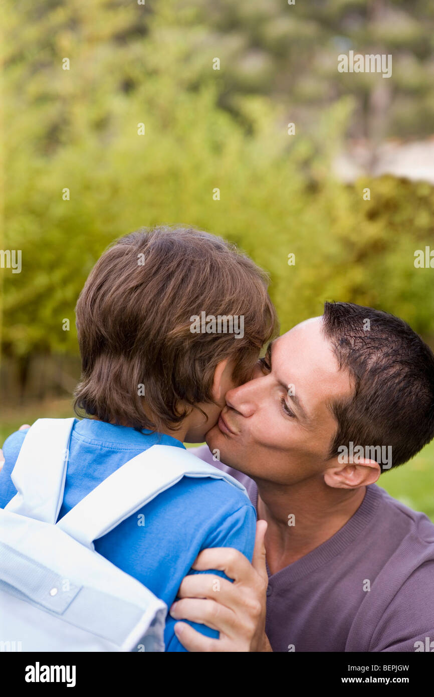 Papà baciare Ragazzo andando a scuola Foto Stock