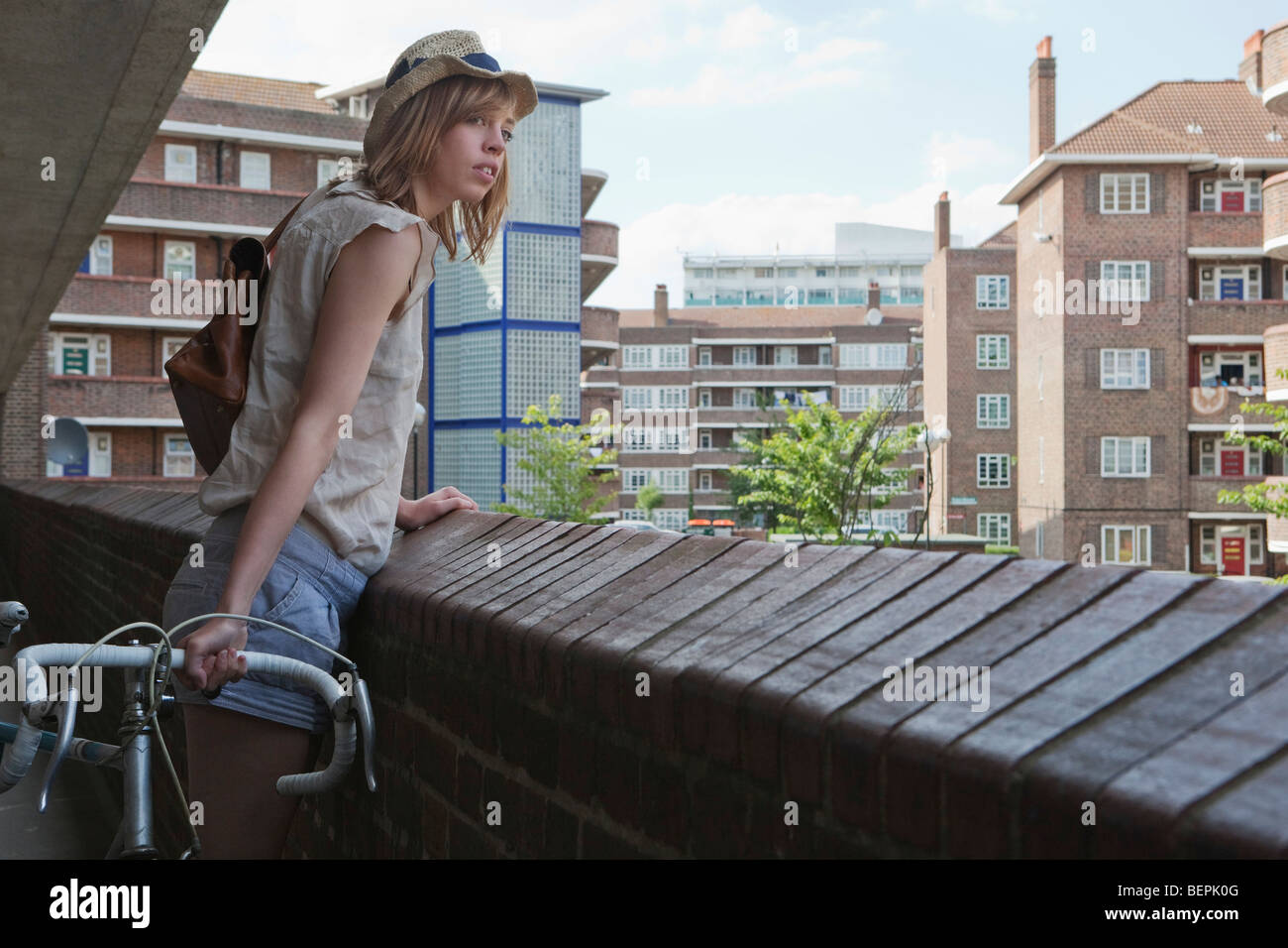 Donna che guarda oltre il balcone Foto Stock