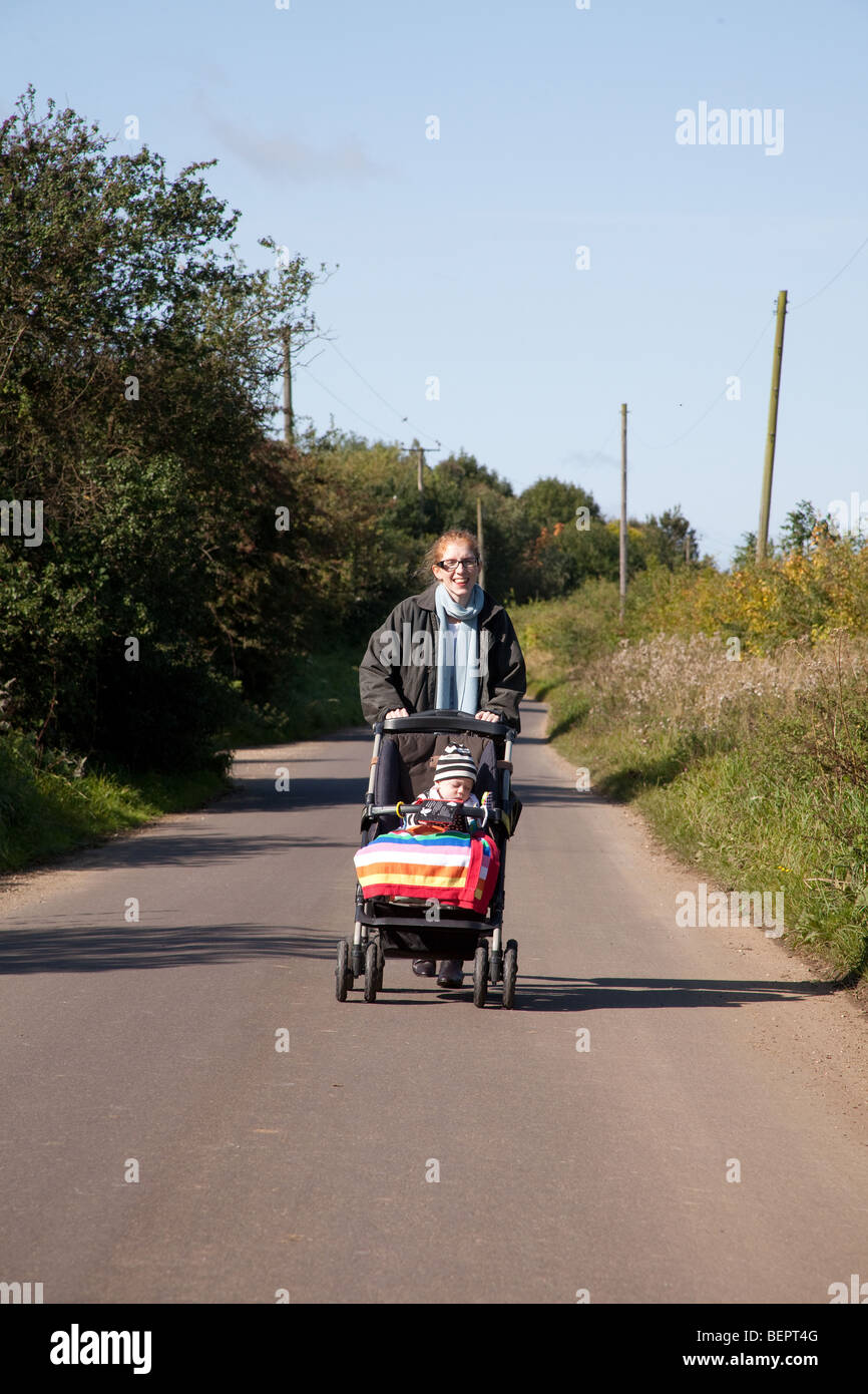 Spingendo la madre di un bimbo in un pushcair Hampshire, Inghilterra. Foto Stock