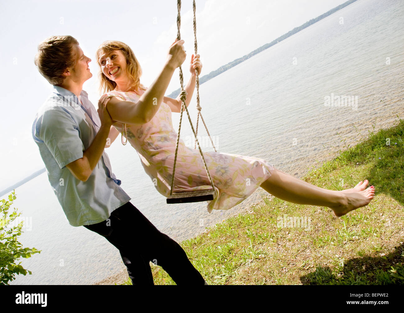 Donna e uomo baciare sulla swing Foto Stock