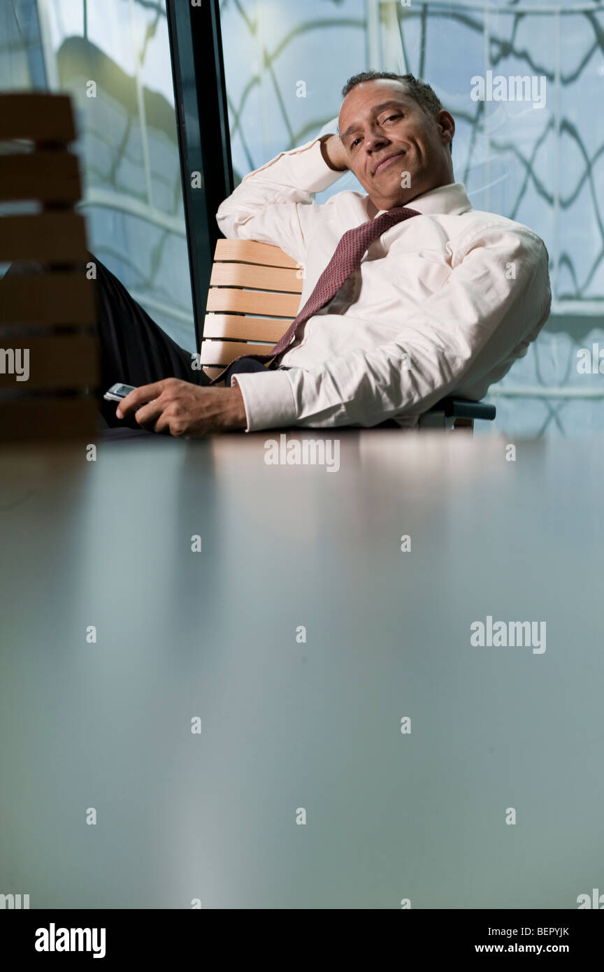 L'uomo Pendente ritornare in cattedra sorridente Foto Stock