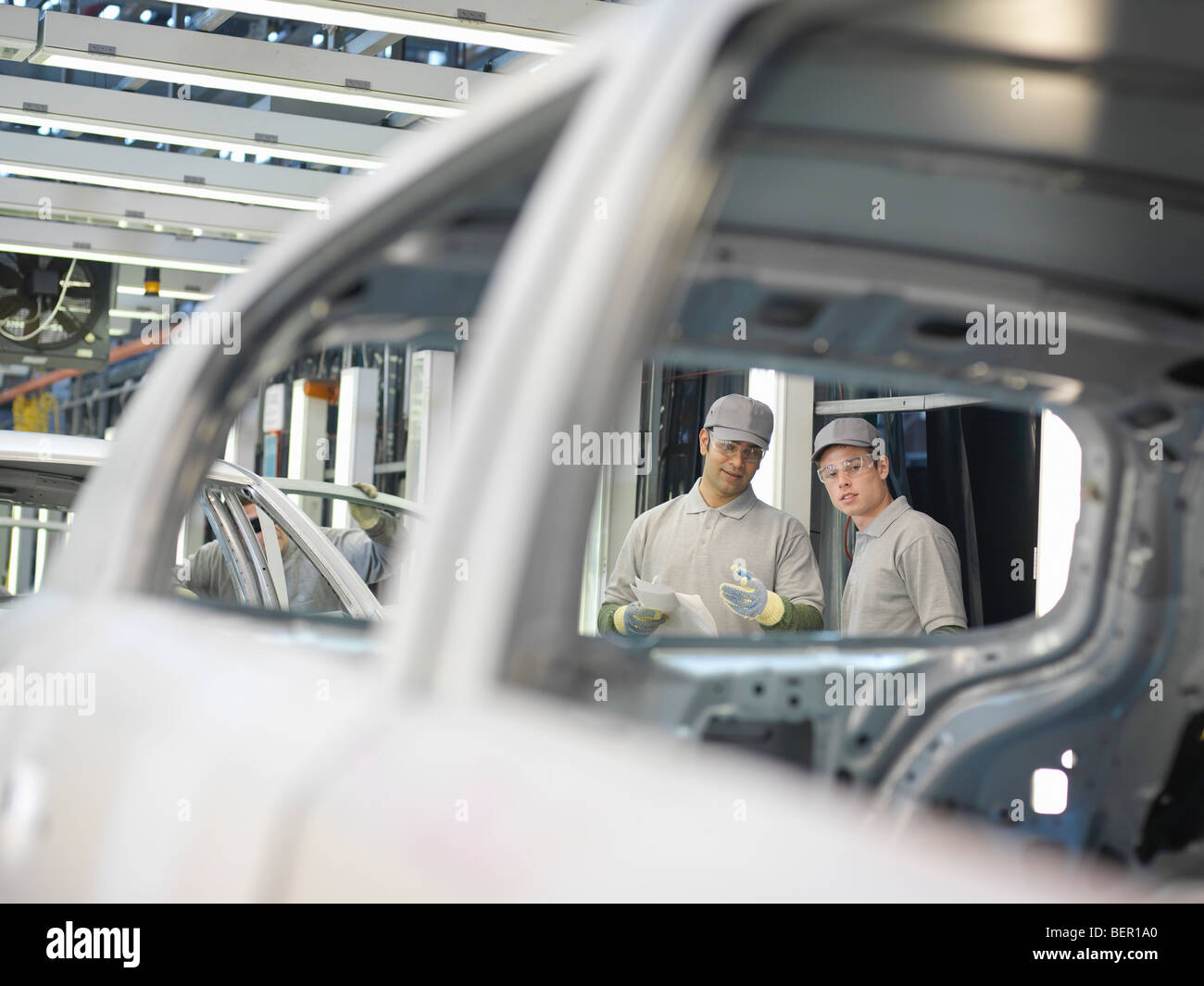 Auto impianti lavoratori discutendo di automobili Foto Stock