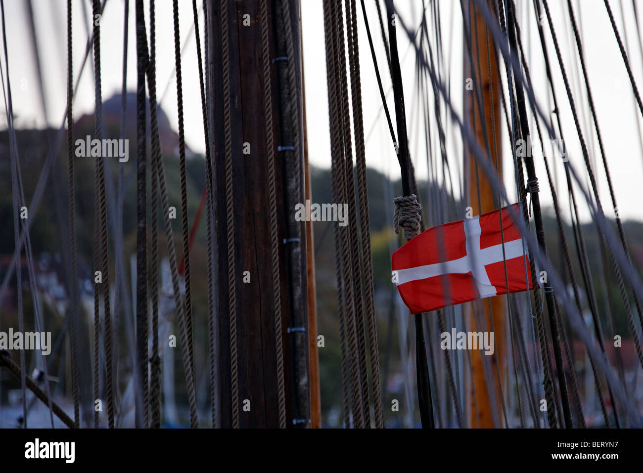 Allestimento di imbarcazioni a vela nel porto di Flensburg, con la bandiera danese e la cupola di Goetheschule Foto Stock