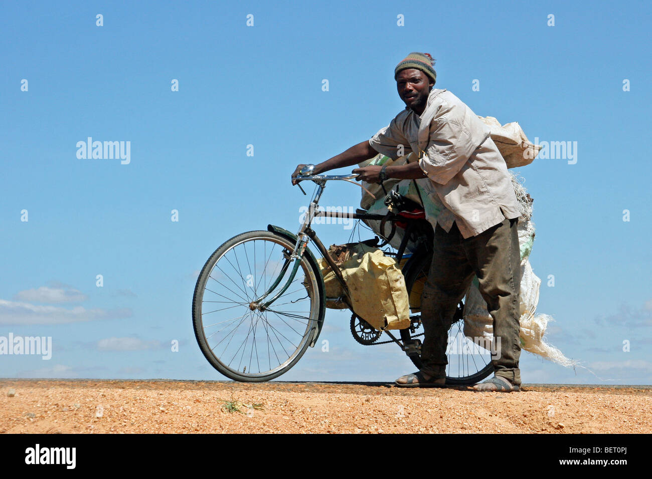 Uomo nero il trasporto di merci in bicicletta, Tanzania Africa orientale Foto Stock