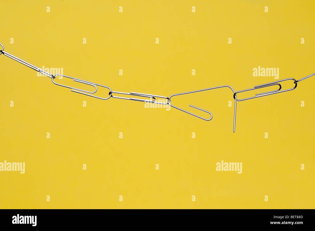 Orizzontale carta di rottura della catena di clip su giallo Foto Stock