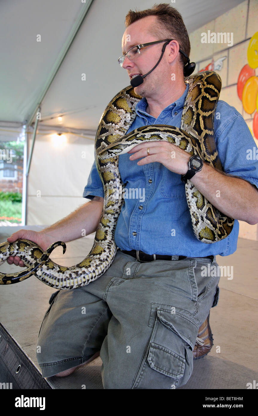 Uomo con python birmano a mostrare degli animali Foto Stock