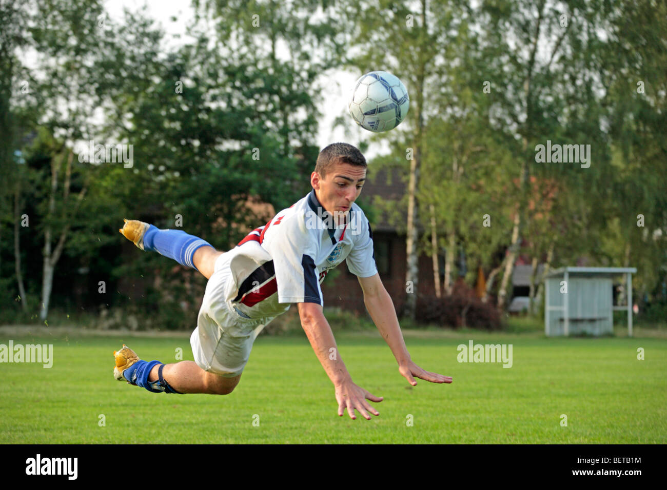 Giovane ragazzo giocando a calcio Foto Stock