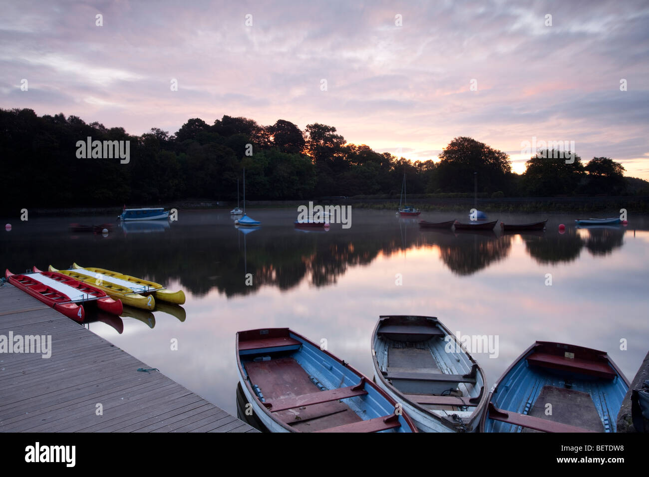Barche a remi che giace inattivo durante la mattina presto all'alba che mostra il blu e malva ricca di colori. Rudyard lago, Staffordshire. Foto Stock