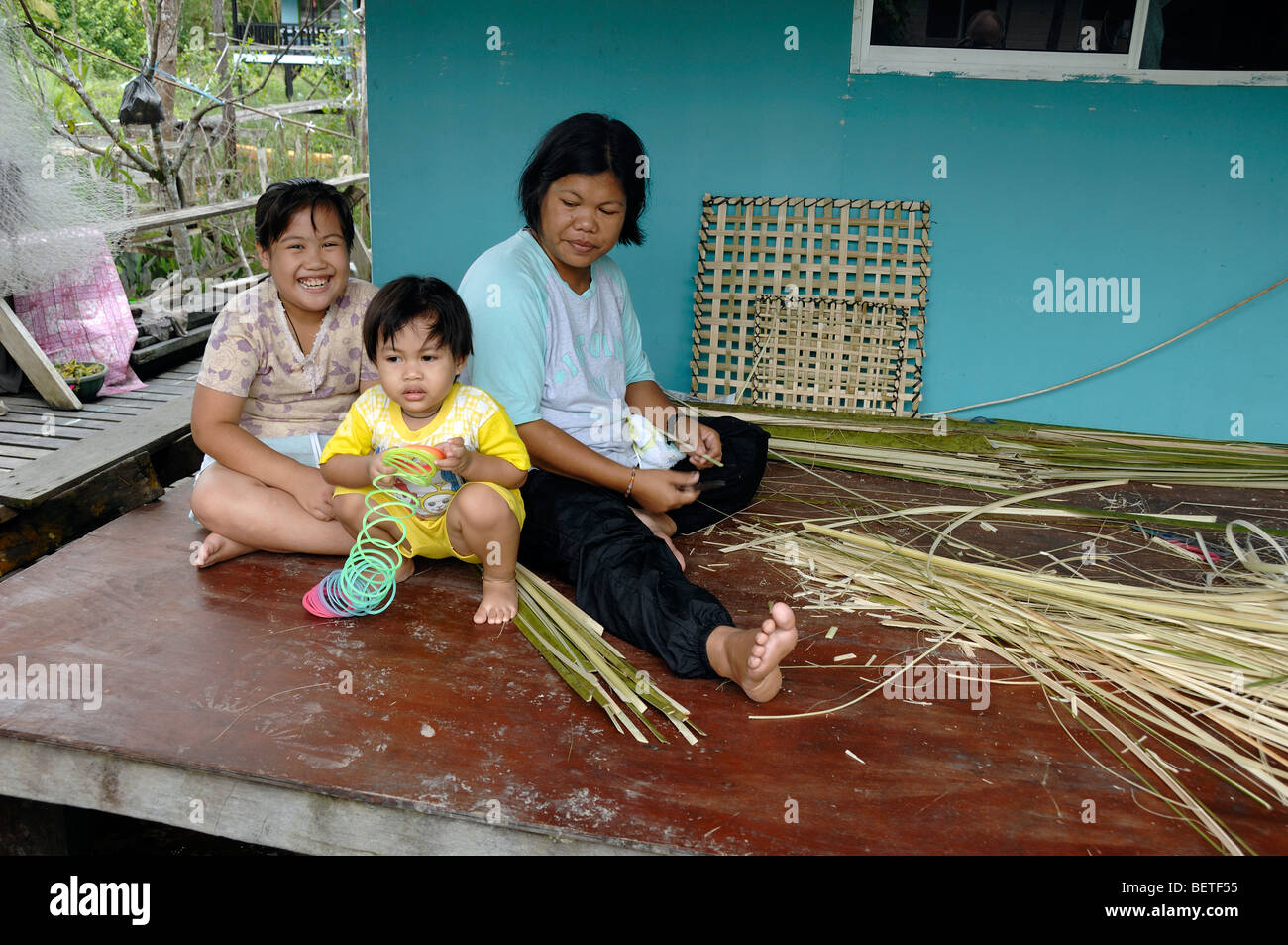 Malaysian o famiglia Sarawakian, Melanau e madre di due figli, Donna tessitura di sago cestini di canna Mukah Sarawak Borneo Malese Foto Stock