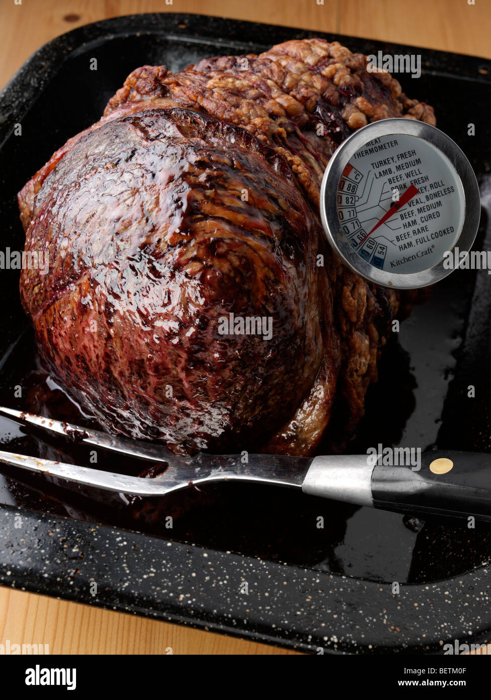 Tutta la fesa giunto della carne bovina irlandese in una teglia da forno a un termometro della carne Foto Stock