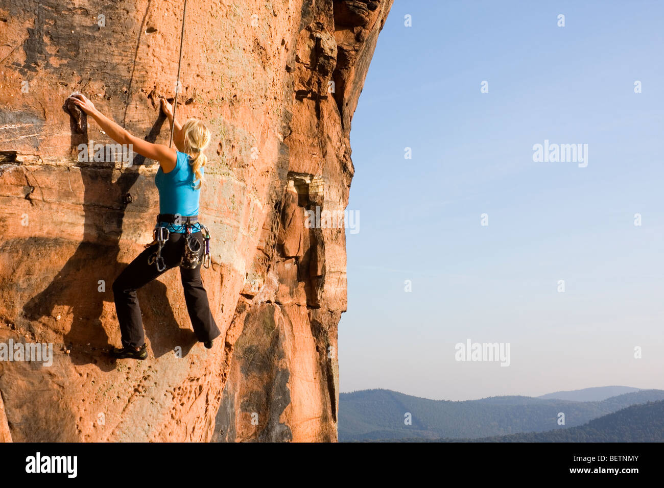 Giovane donna arrampicata su una roccia di arenaria Foto Stock