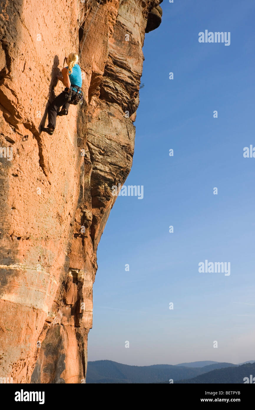 Giovane donna arrampicata su una roccia di arenaria Foto Stock