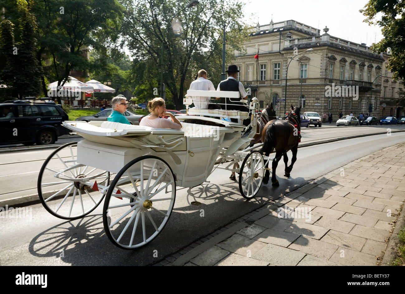 Carrozza per il trasporto di passeggeri per turismo intorno a Cracovia, trot vicino alla piazza principale del mercato / Markt Square. Cracovia. La Polonia. Foto Stock