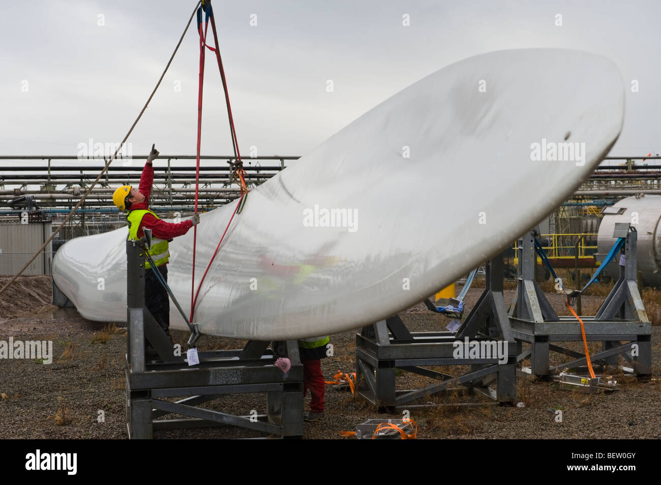 Riggers preparazione di gru per il sollevamento di lame per essere montato a Nordex N90 turbine eoliche in costruzione al Regno Unito Foto Stock