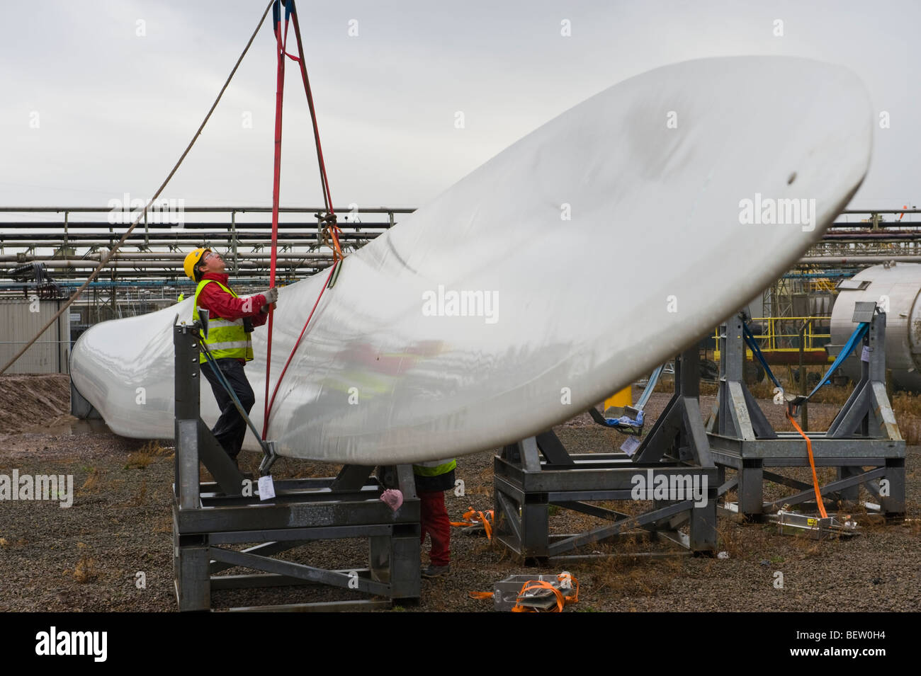 Riggers preparazione di gru per il sollevamento di lame per essere montato a Nordex N90 turbine eoliche in costruzione al Regno Unito Foto Stock