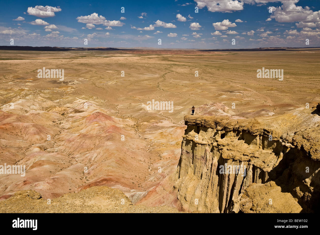 Uomo in piedi sul bordo di un alto promontorio che domina il deserto del Gobi mongolia Foto Stock