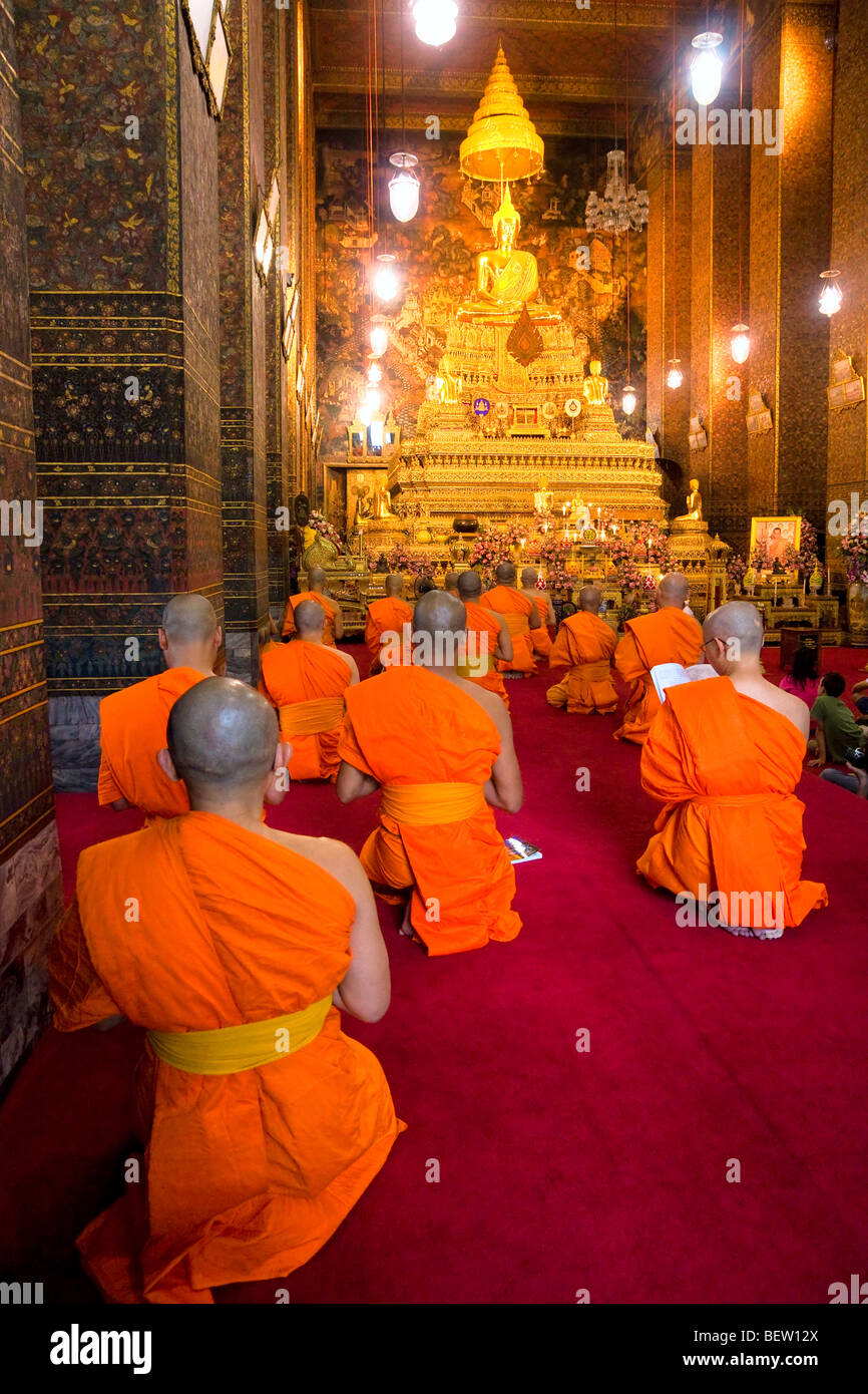 Monaco pregare all'interno di un tempio di Wat Po complesso. Bangkok, Thailandia Foto Stock