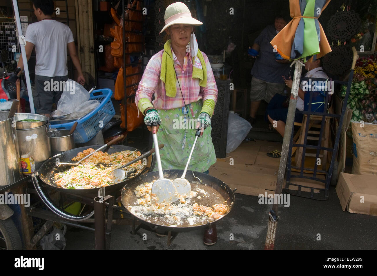 Fornitore rendendo pad thai tagliatelle al Mercato del fine settimana di Chatuchak a Bangkok in Tailandia Foto Stock