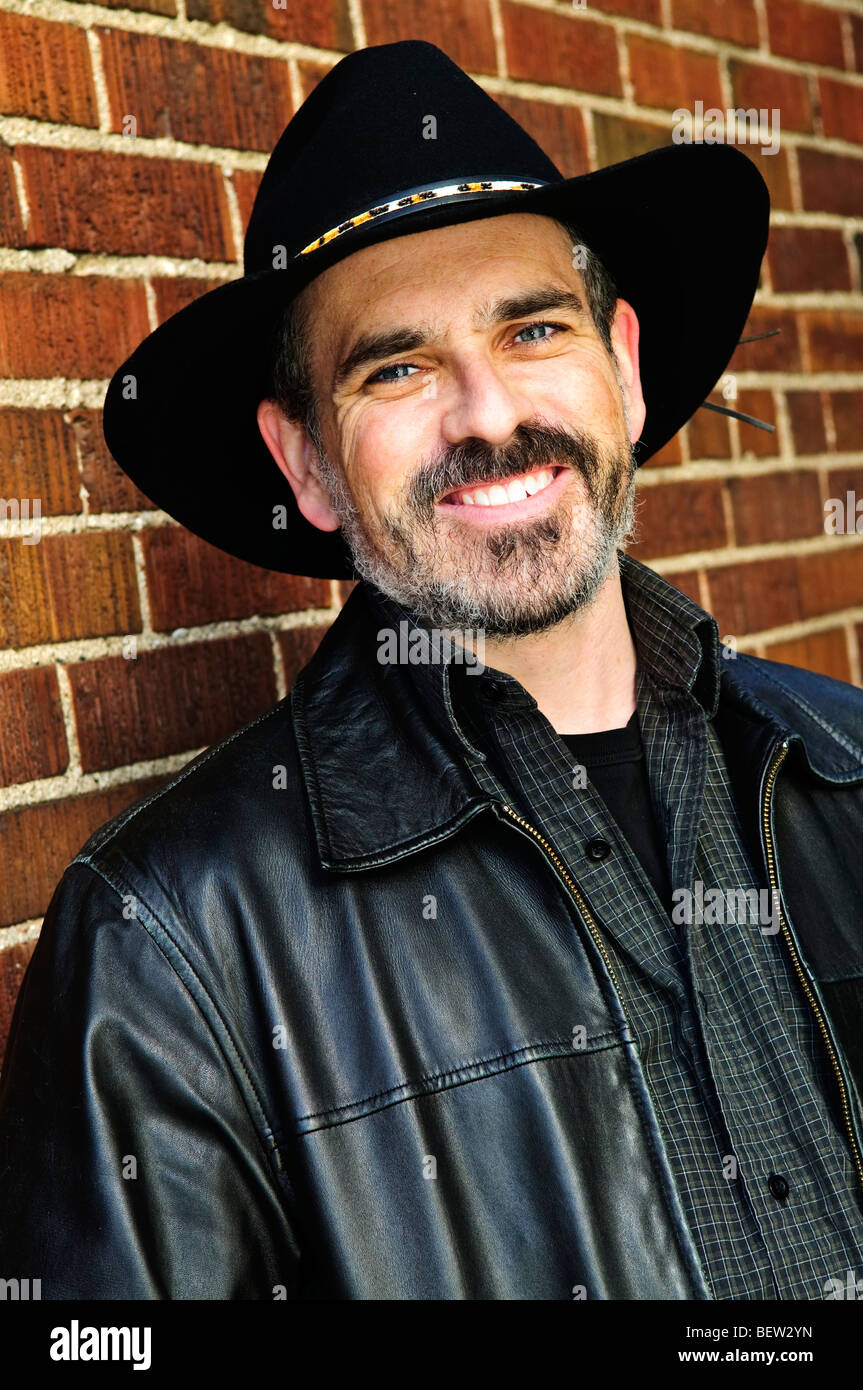 Uomo con la barba nel cappello da cowboy e giacca di pelle Foto stock -  Alamy
