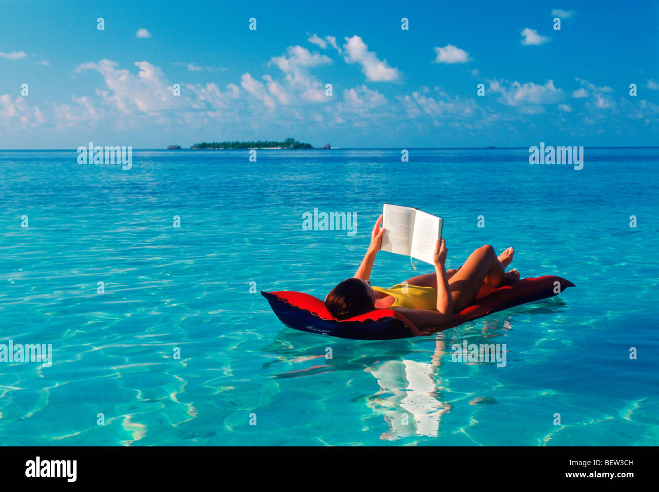 Donna in appoggio sul materasso ad aria in modo chiaro la calma aqua acque  dell'Oceano Indiano con le Maldive in distanza Foto stock - Alamy