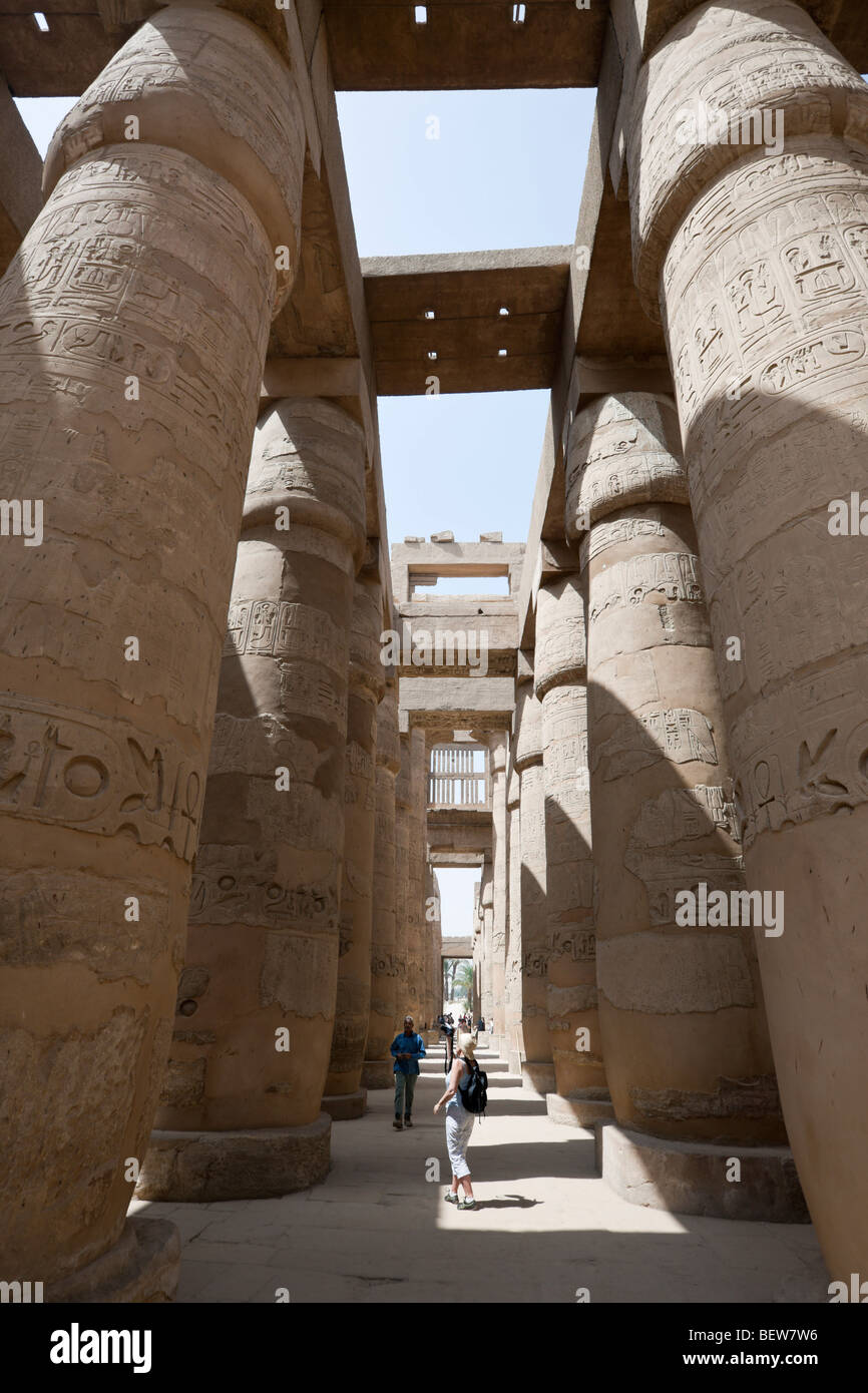 I turisti tra i pilastri di grande Hypostyle Hall presso il Tempio di Karnak Luxor Egitto Foto Stock