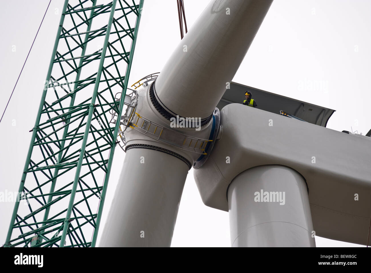 Gli ingegneri di lame di raccordo sollevata dalla gru a Nordex N90 turbine eoliche in costruzione in Newport South Wales UK Foto Stock