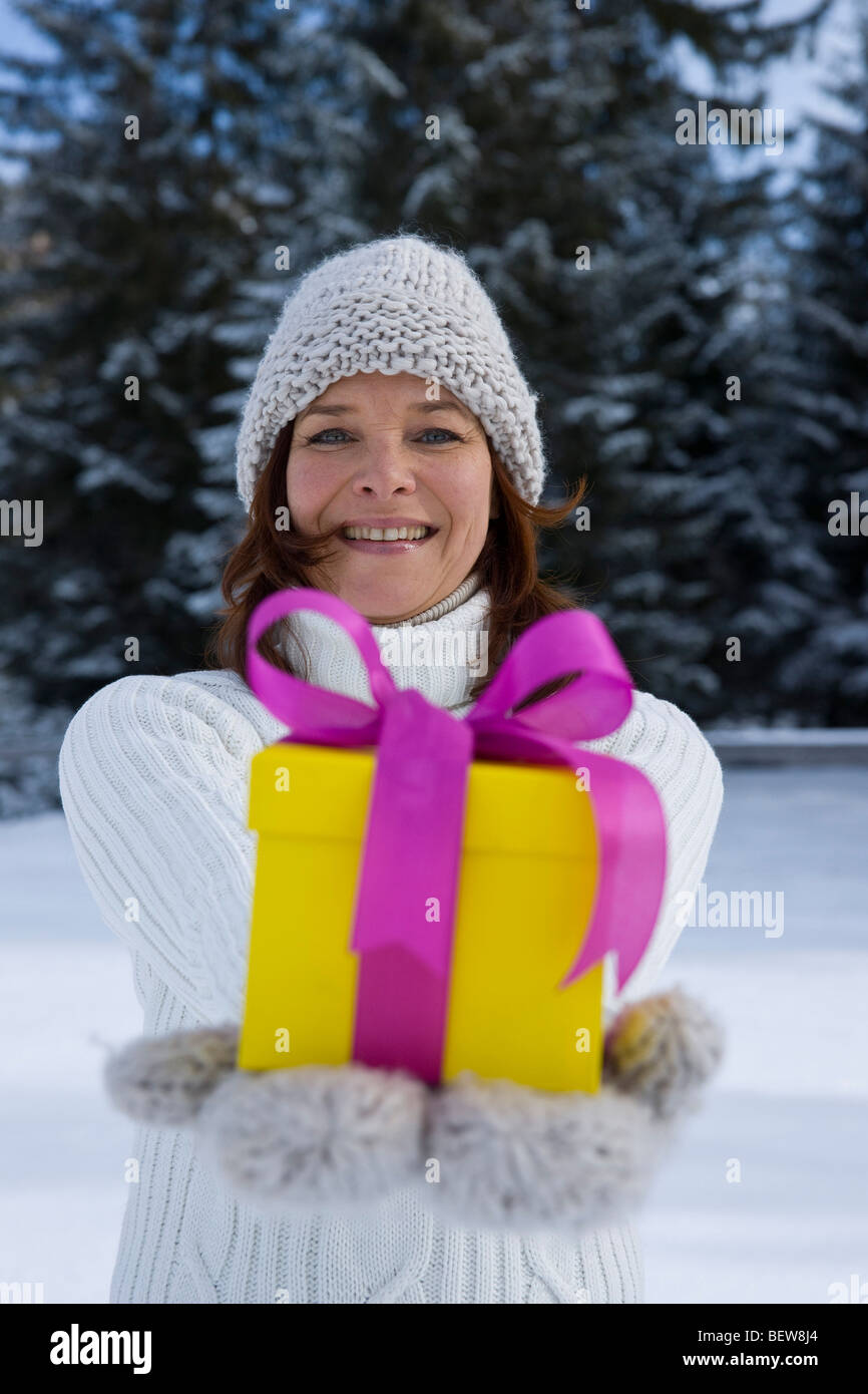 Donna che mantiene un regalo di Natale e sorridente Foto Stock