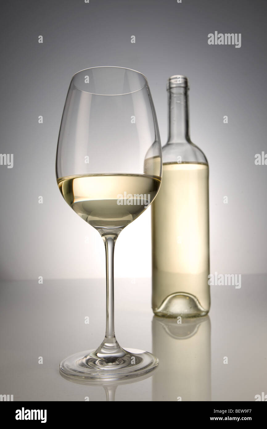 Vetro e bottiglia di vino bianco, close-up Foto Stock