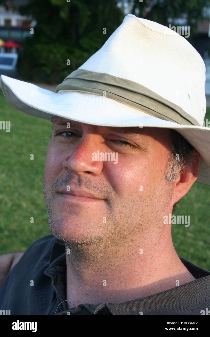 Attraente uomo in bianco cappello di Panama godendo il sole Foto Stock