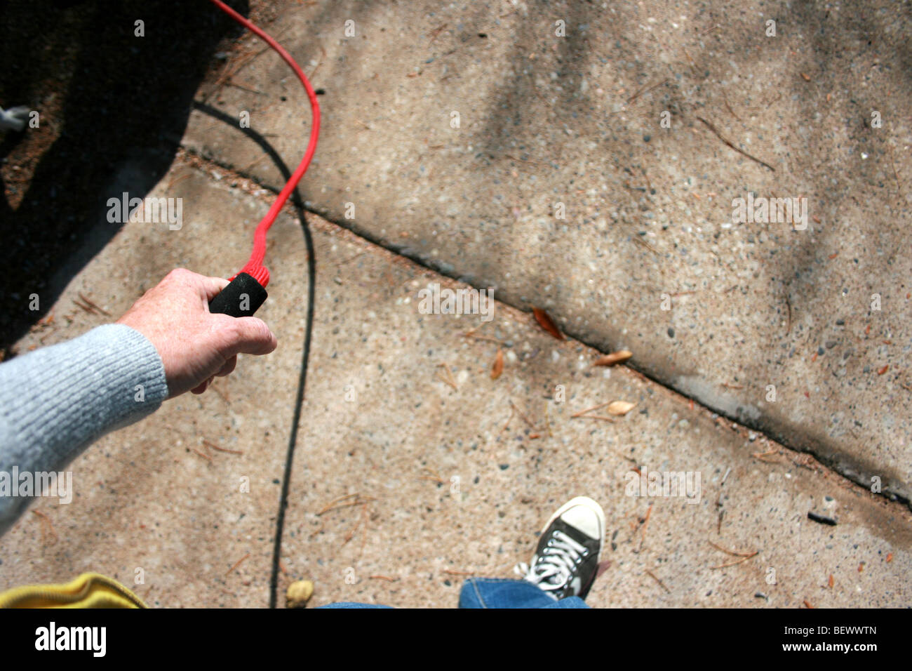 Una persona a piedi un cane, solo guinzaglio, il braccio e la calzatura visibile Foto Stock