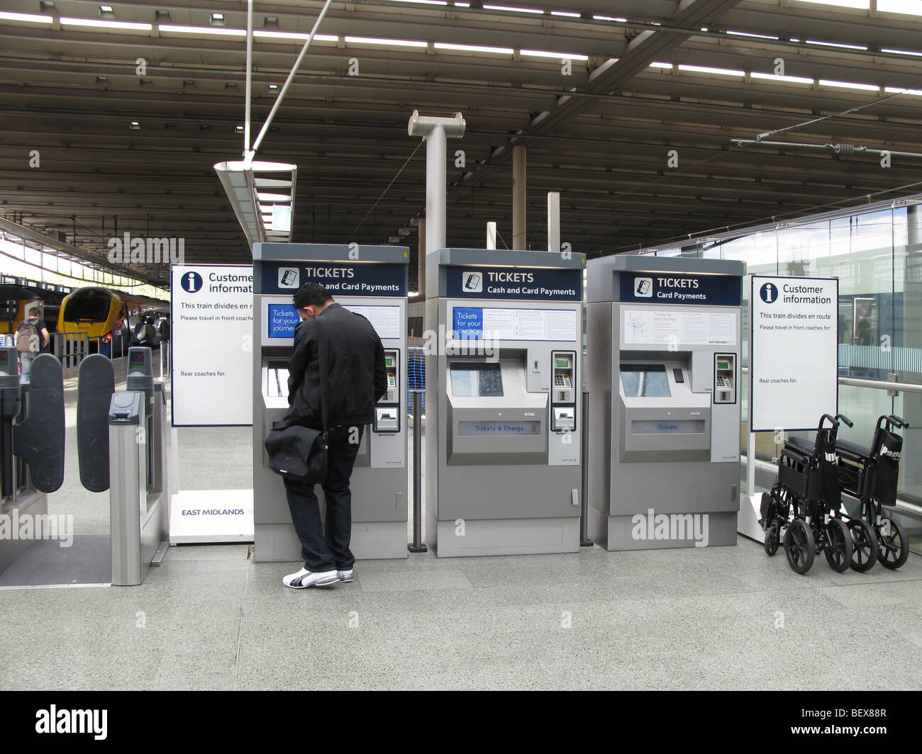 Utilizzando il self-service ticket machine stazione ferroviaria internazionale di St Pancras, London Foto Stock