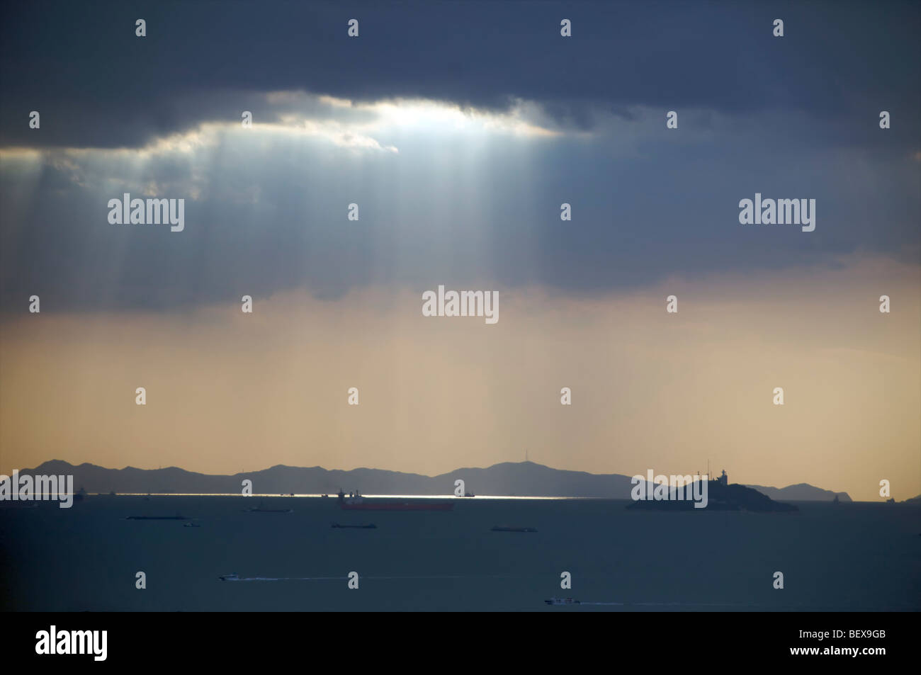 Alberi di luce del sole alla fine di una tempesta al di sopra del mare principale corsia di ingresso al Porto di Incheon, Corea del Sud. Foto Stock