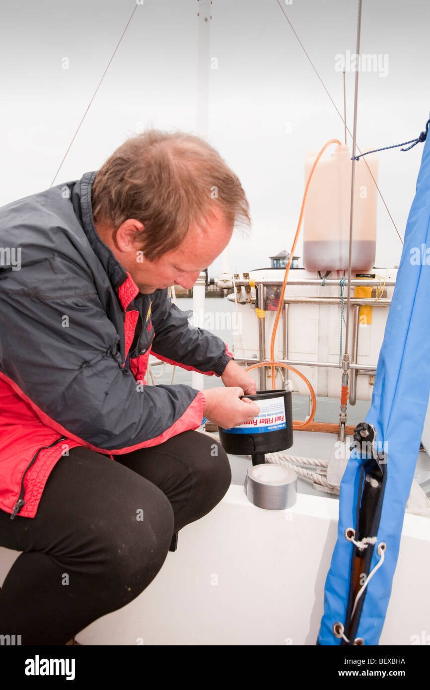 Un marinaio riempie la sua barca motore serbatoi di gasolio, Whitehaven, Cumbria, Regno Unito Foto Stock