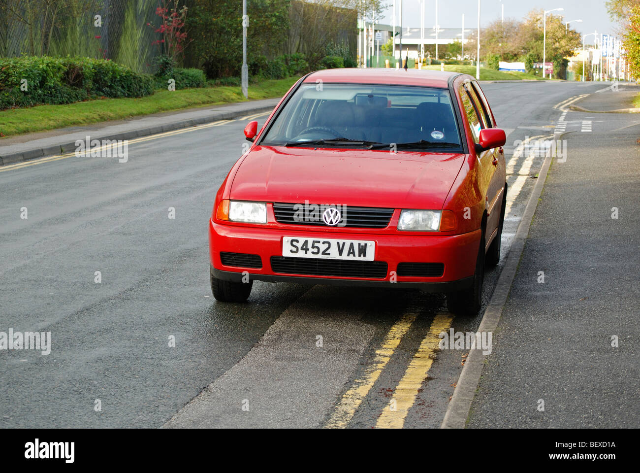 Un rosso Volkswagen Polo parcheggiata su doppio giallo linee, Bolton, Regno Unito Foto Stock