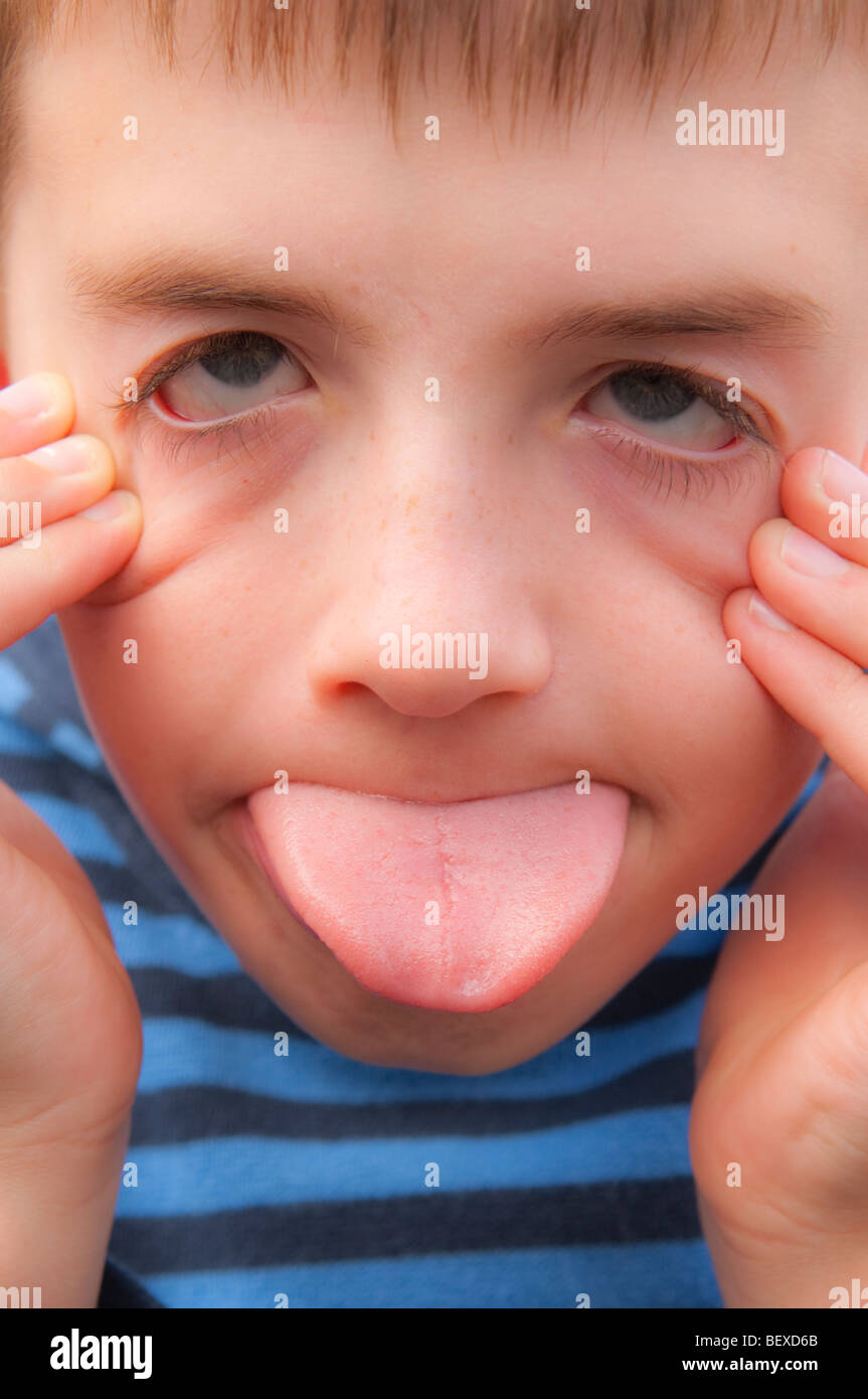 Un modello rilasciato ragazzo di nove anni tirando una buffa faccia nel Regno Unito Foto Stock