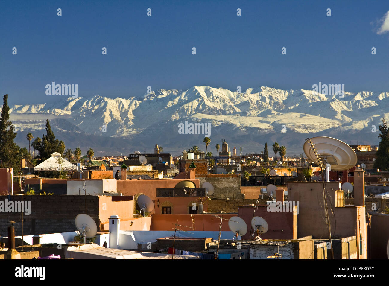 Parabole satellitari. Vista dalla parte superiore del tetto di Marrakech con snowy atlas mountain in background. Il Marocco, Africa del nord Foto Stock