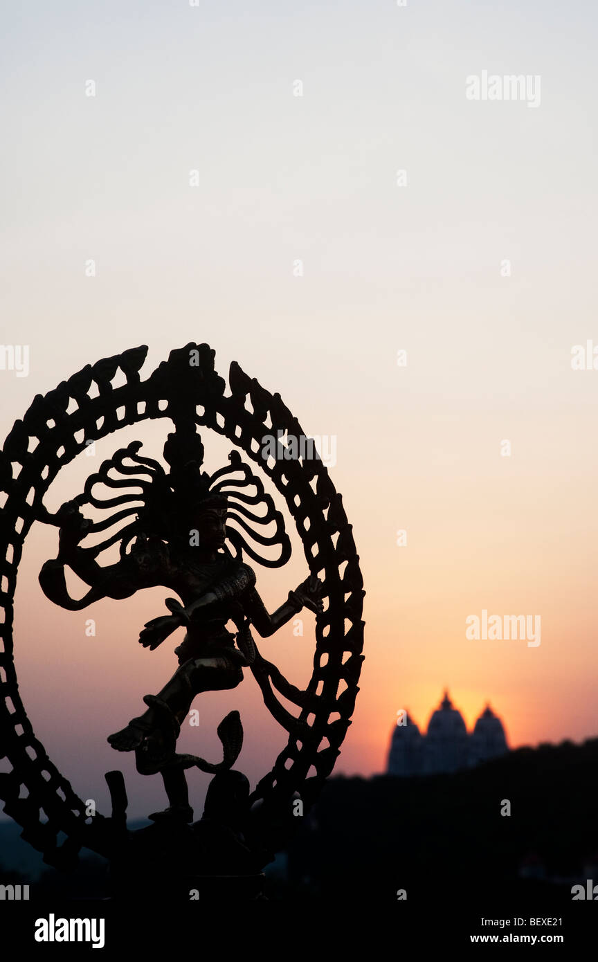 Dancing signore Shiva statua, Nataraja silhouette, contro un tempio indiano sunrise sfondo. India Foto Stock