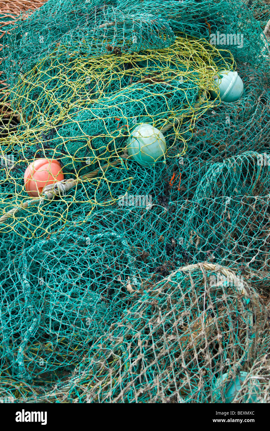 Un groviglio di reti e dei galleggianti impilati su un molo scozzese Foto Stock